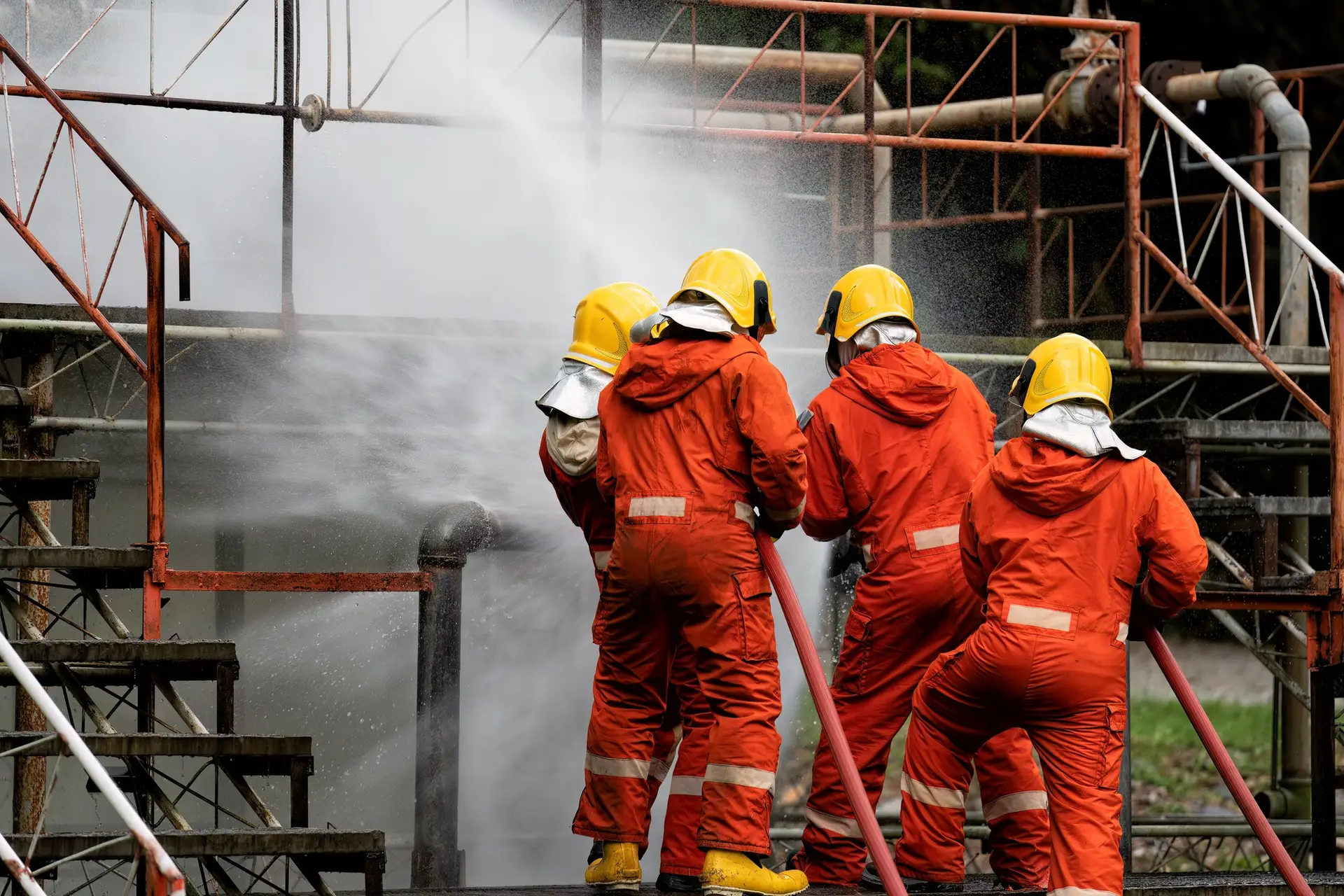 Fire fighter team on training with gas and oil fire at pipe line and valve spray jet water Fire fighter team on training with gas and oil fire at pipe line and valve spray jet water