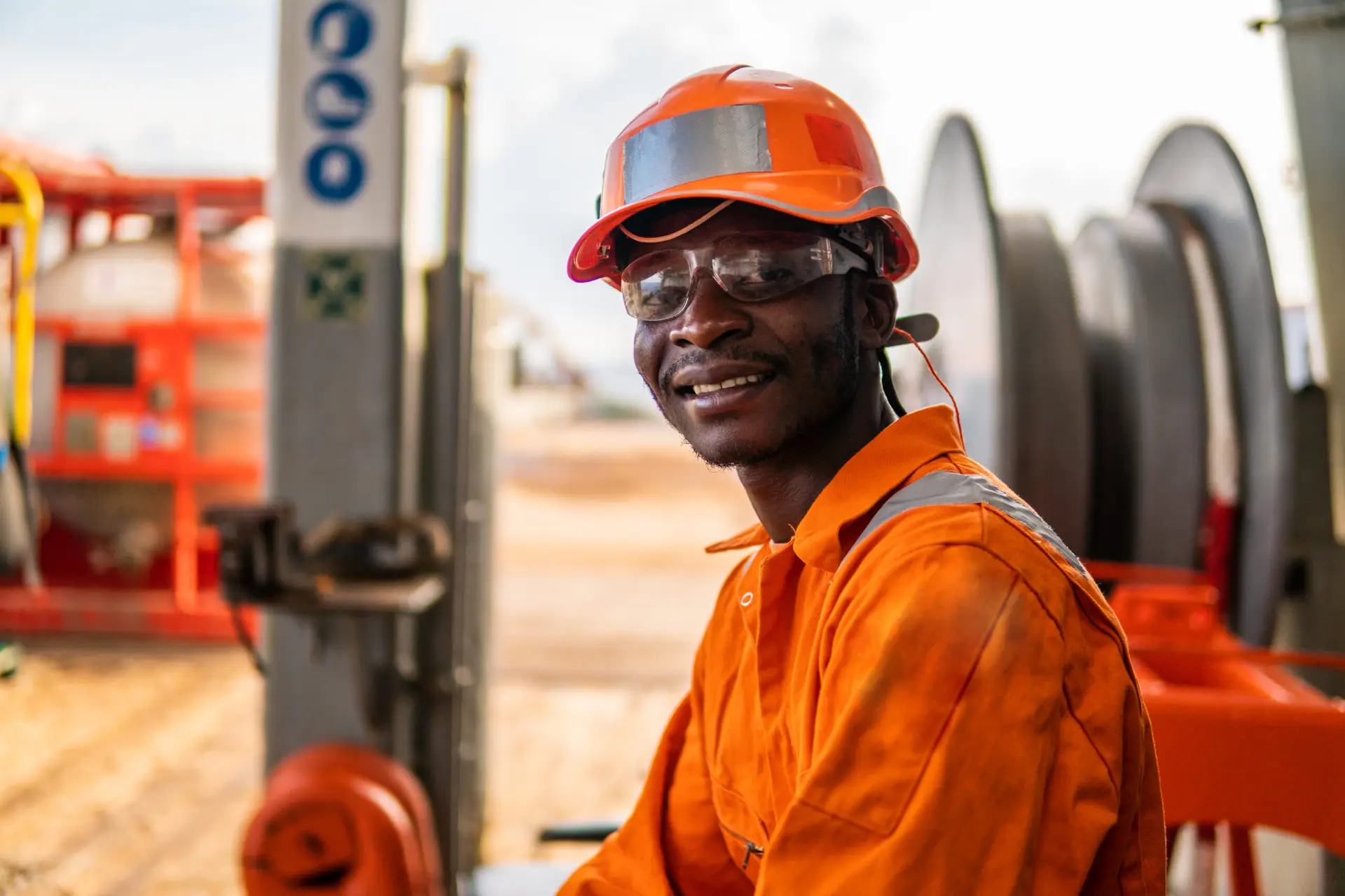 happy Seaman AB or Bosun on deck of vessel or ship happy Seaman AB or Bosun on deck of vessel or ship , wearing PPE personal protective equipment - helmet, coverall, lifejacket, goggles. Safety at sea