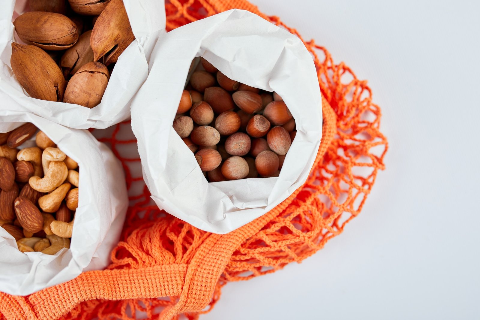 Top view of various sort of nuts on the table in a paper bag in shopping grocery