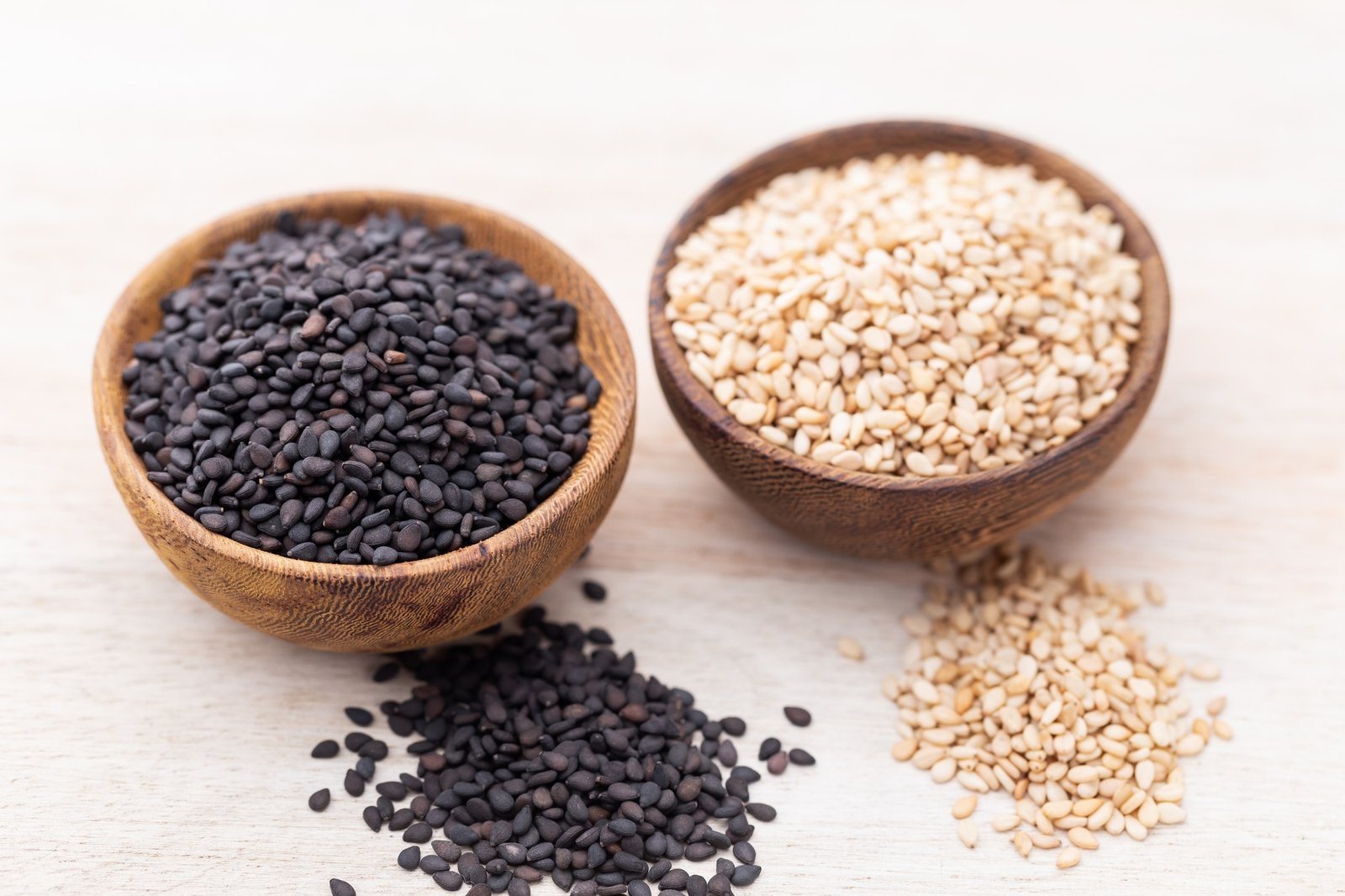 White sesame and black sesame seed on wooden bowl.